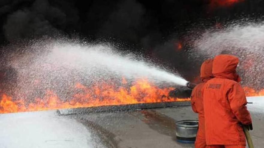 Participantes en el curso, durante una de las prácticas para sofocar un fuego.