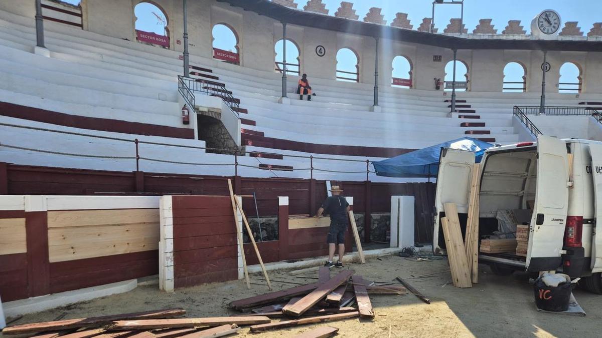 Un operari canvia taulons de fusta que patien deteriorament
