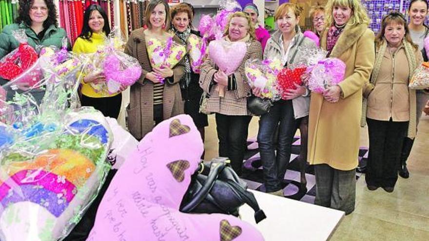 Algunas alumnas y colaboradoras del taller de costura posan con María Miras -tercera por la izquierda- y con los cojines.