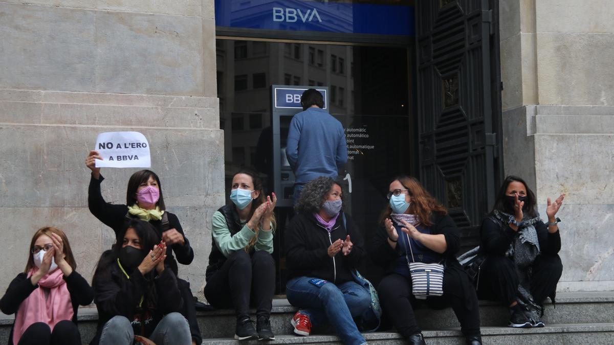 Diversos treballadors del BBVA davant l&#039;antiga seu de Caixa Catalunya, situada a la plaça Antoni Maura de Barcelona