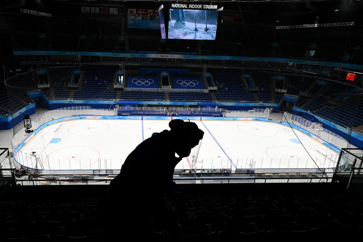 Un trabajador limpia las gradas en el Estadio Nacional, donde se van a celebrar las competiciones de hockey sobre hielo.