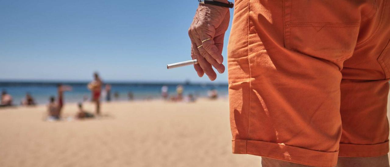 Un ciudadano sostiene un cigarro en su mano, en la playa de Las Teresitas, en Santa Cruz de Tenerife.