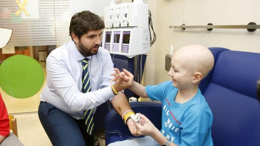 José, un paciente de Oncología Pediátrica de 11 años, puso ayer un tatuaje del lazo dorado al presidente de la Región.