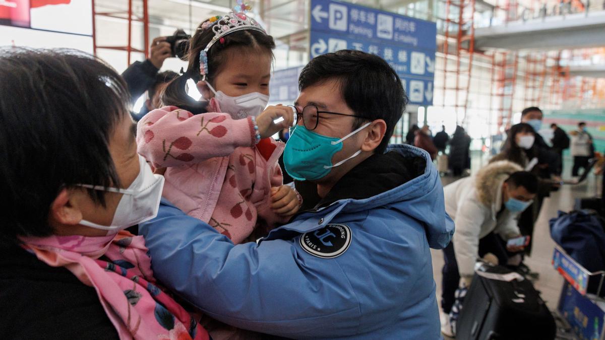 La gente se abraza en la puerta de llegadas internacionales del Aeropuerto Internacional Capital de Pekín después de que China levantara el requisito de cuarentena por COVID-19 para los viajeros entrantes en Pekín