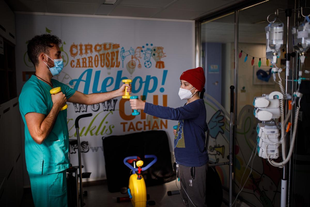 El fisioterapeuta Denys Santa Marina trabaja con un paciente de cáncer infantil.
