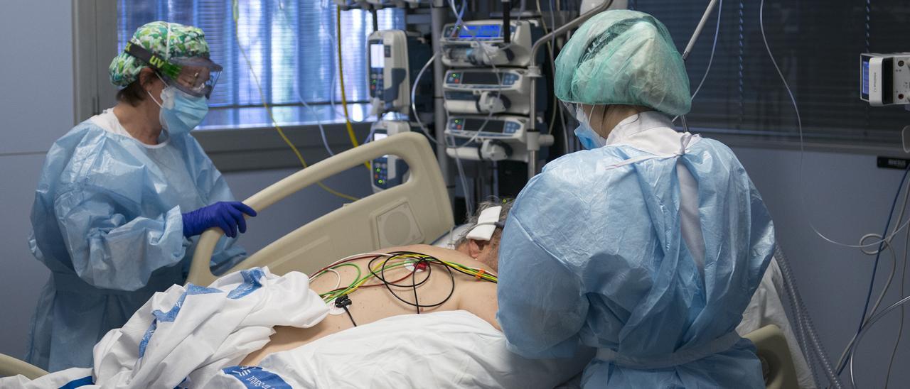 Personal sanitario atendie a un paciente con COVID en la uci