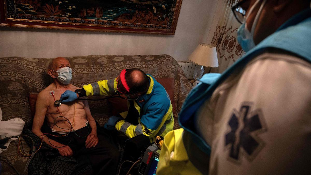 SUMMA 112 (Medical Emergency Services of Madrid) doctor Juan Jose Fernandes attends to an elderly man at his home in Madrid on November 6, 2020. - The novel coronavirus has killed at least 1,255,803 people since the outbreak emerged in China last December, according to a tally from official sources compiled by AFP on November 9. (Photo by PIERRE-PHILIPPE MARCOU / AFP)