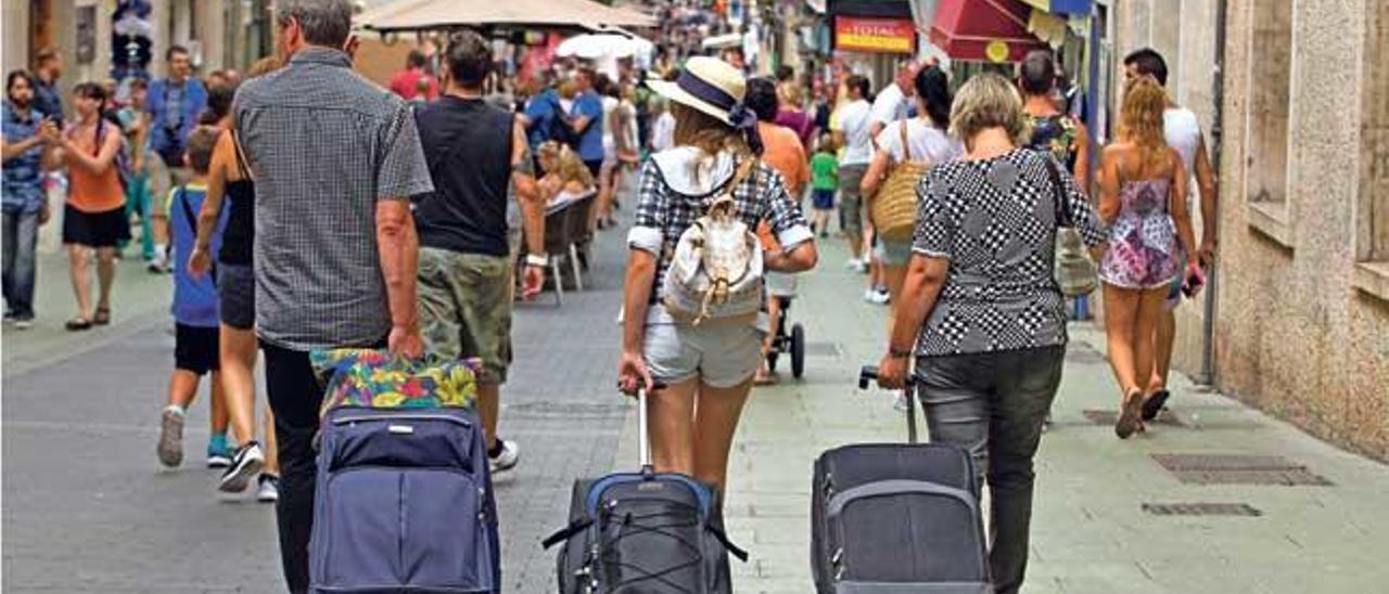 Maletas por el centro: el turismo de alquiler residencial y los hoteles boutique han convertido esta escena en habitual de Palma.