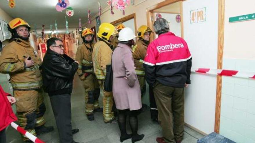 Técnicos municipales, junto a los bomberos, momentos después de ceder el suelo de un aula.