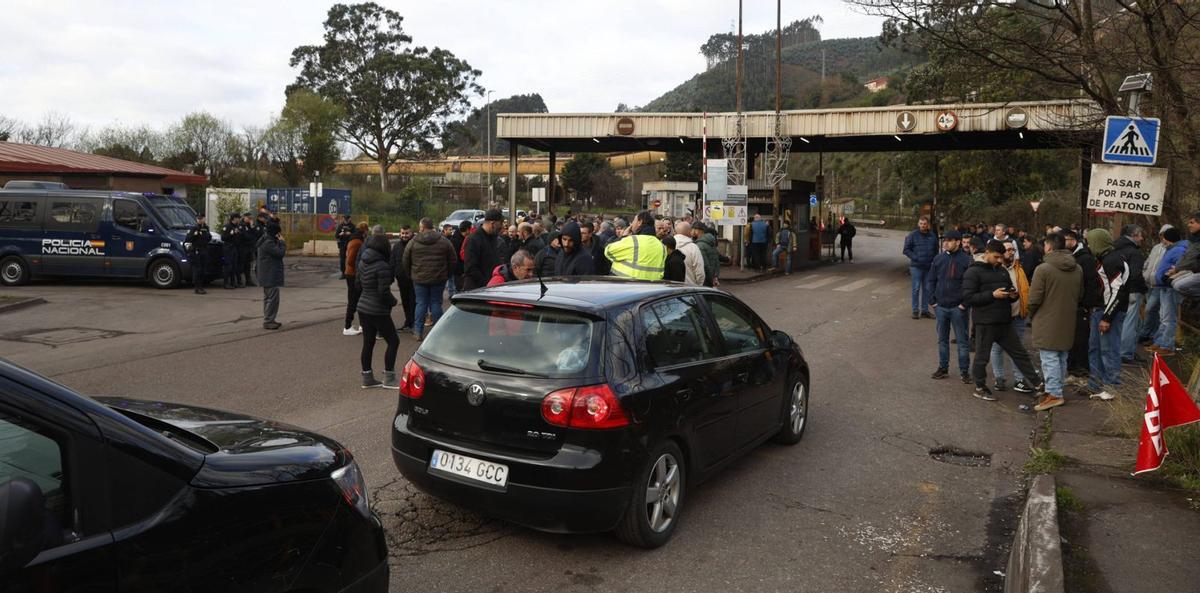 Trabajadores de empresas auxiliares «controlan» el acceso a la planta de ArcelorMittal en Gijón bajo la vigilancia de la Policía Nacional. | JUAN PLAZA