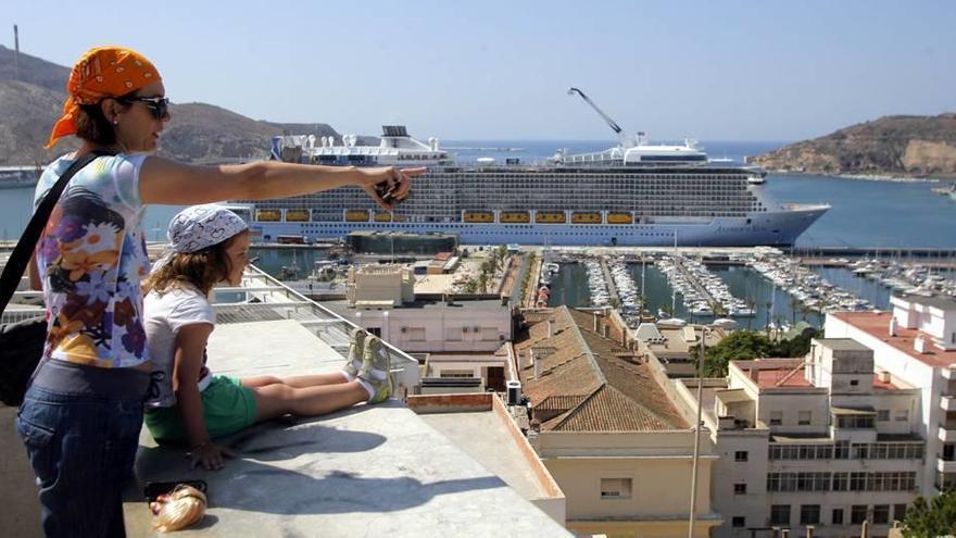 Unos turistas divisan el puerto de Cartagena desde el mirador del Parque Torres.