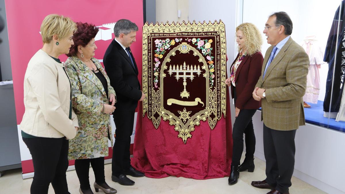 La bordadora Silvia Teruel (d.) comenta las técnicas utilizadas en la pieza.