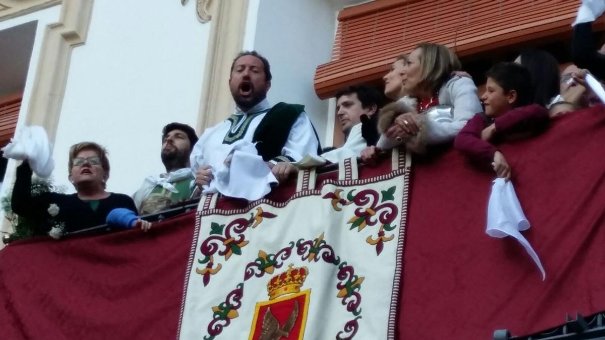 Ángel García Aragón gritando vivas desde el balcón principal de su casa familiar en la Plaza de España a la bandera del Paso Blanco tras su recogida.