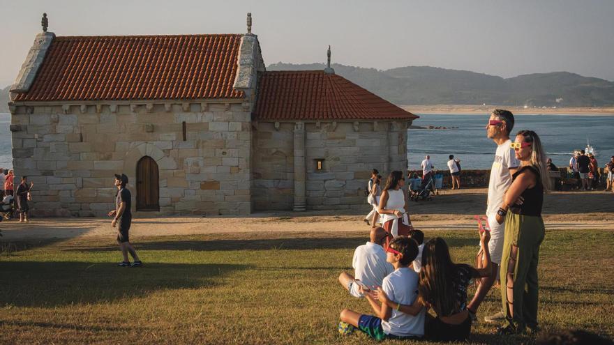 Gente observado el eclipse en las inmediacones de la ermita de A Lanzada