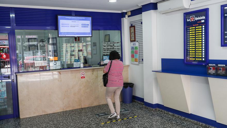 Una mujer compra lotería en una Administración, archivo