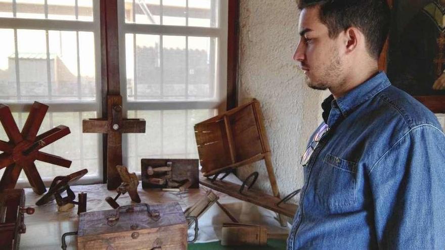 Un joven observa la colección de carracas y matracas en el museo de la iglesia de Santa Marta de Tera.