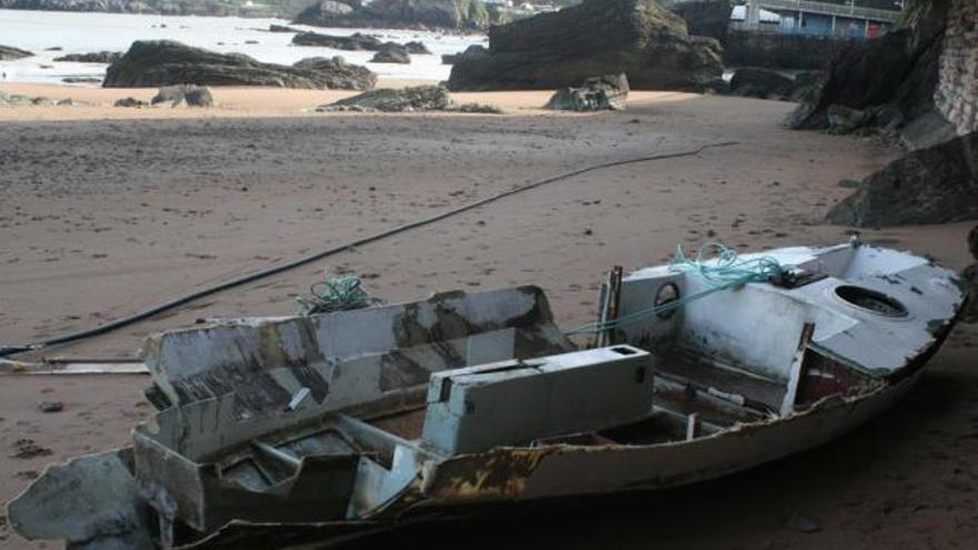 Los restos de una de las embarcaciones que destrozó el oleaje, ayer, en la playa de La Palmera de Candás.
