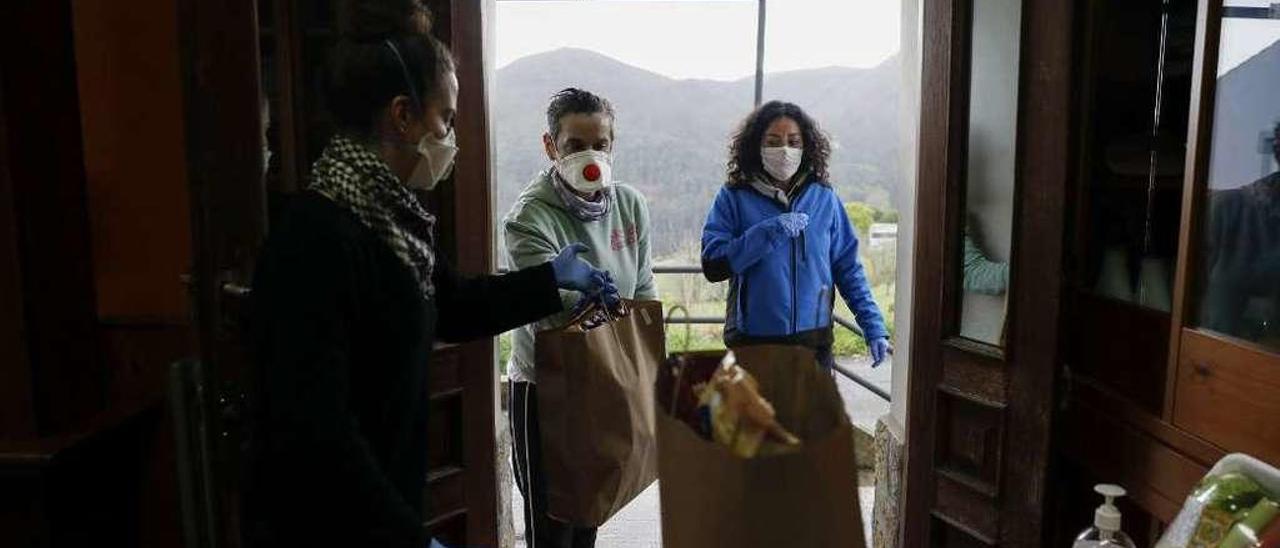 Conchi González y Alejandra Figueroa recogen bolsas de comida en el bar-tienda de La Peral (Illas).