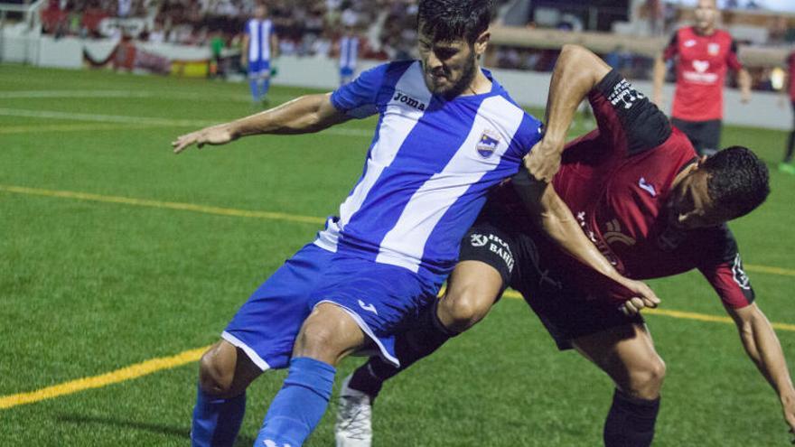 Carlos Martínez es sujetado por un rival en un lance de un partido.