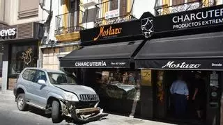 Un coche pierde el control y se empotra contra el escaparate de una charcutería Mostazo en Cáceres