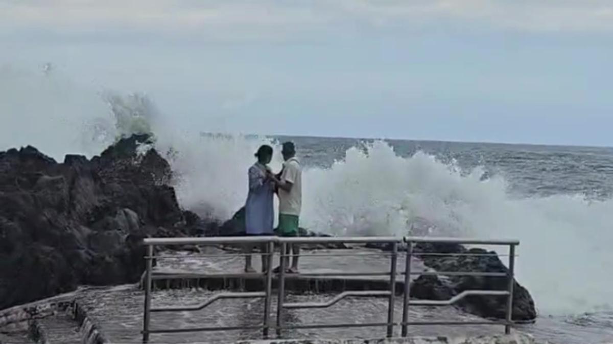 Una pareja en la costa de Garachico durante un día de marea equinoccional.