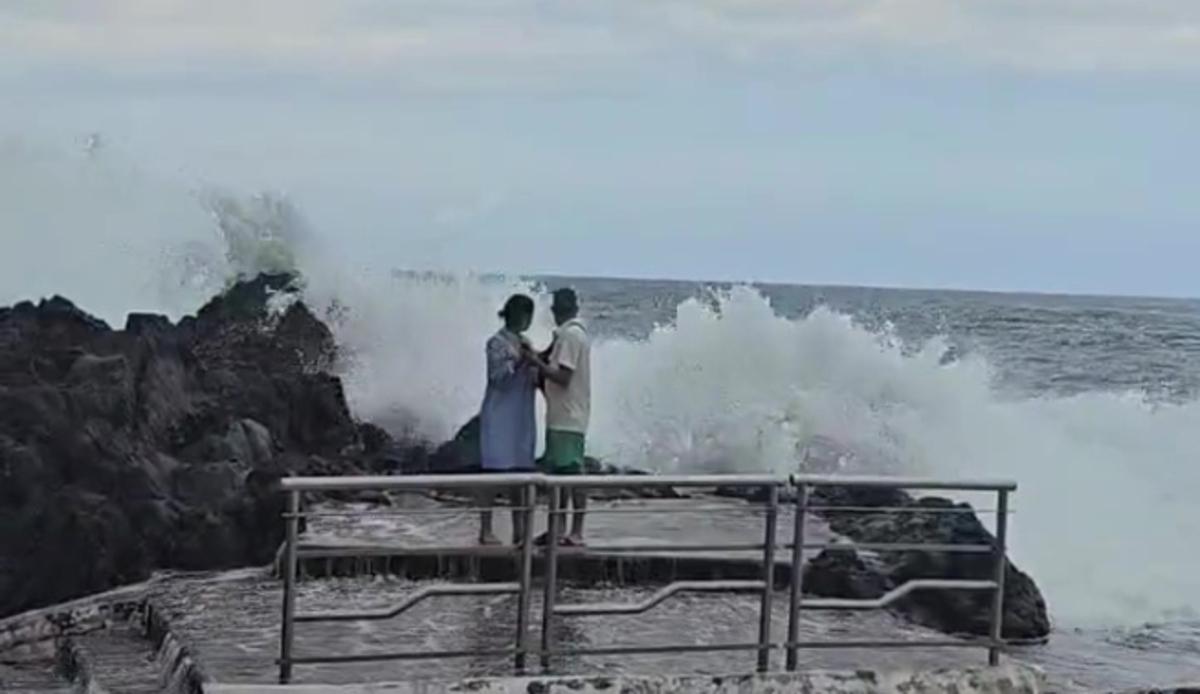 Una pareja en la costa de Garachico durante un día de marea equinoccional.