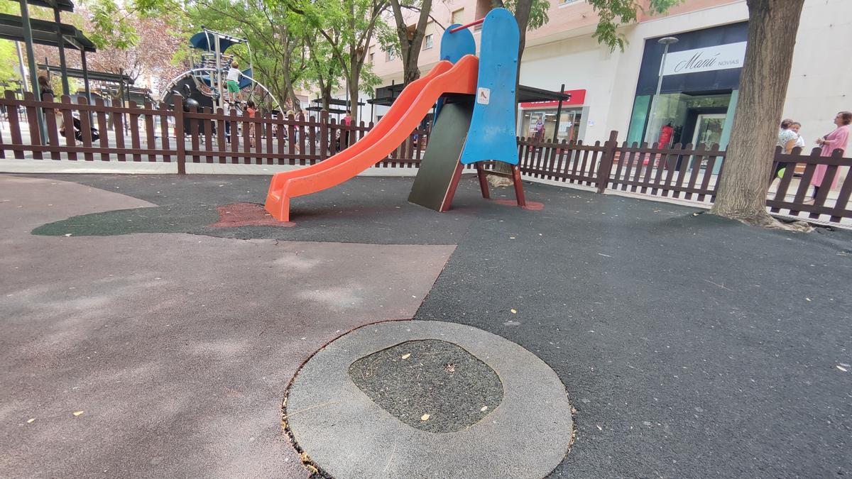 Área infantil del parque de Pardaleras, con un único tobogán y el suelo deteriorado.