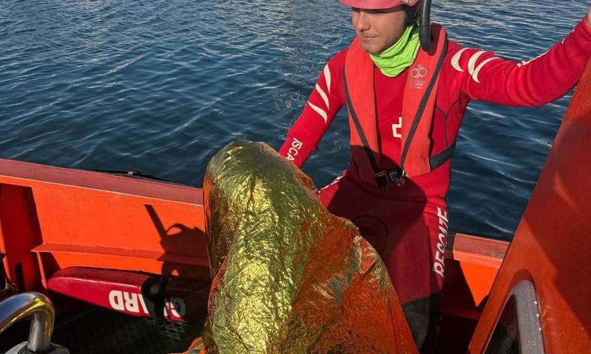 Un miembro de Cruz Roja con el hombre de 37 años rescatado.