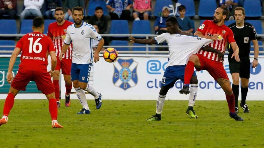 Borja, del Almería, sujeta por la camiseta a Amath en presencias de Fidel, de espaldas, y el exoviedista Aitor Sanz, en el partido de ayer entre el Tenerife y el Almería disputado en el Heliodoro Rodríguez López.