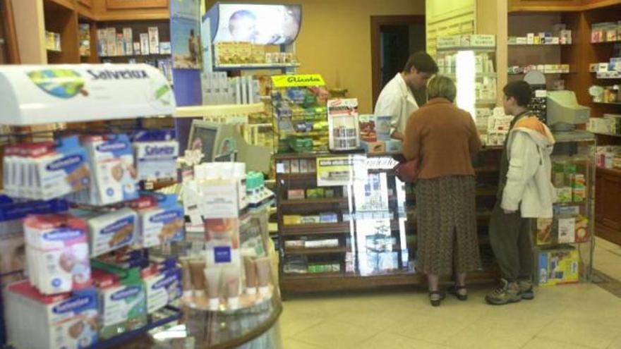 Un farmacéutico atiende a varios clientes. / roberto aguete