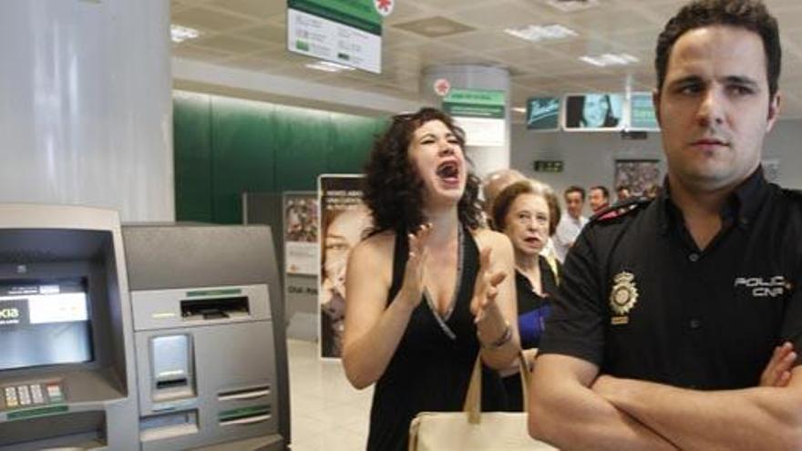 Una mujer protesta en una sucursal de Bankia.