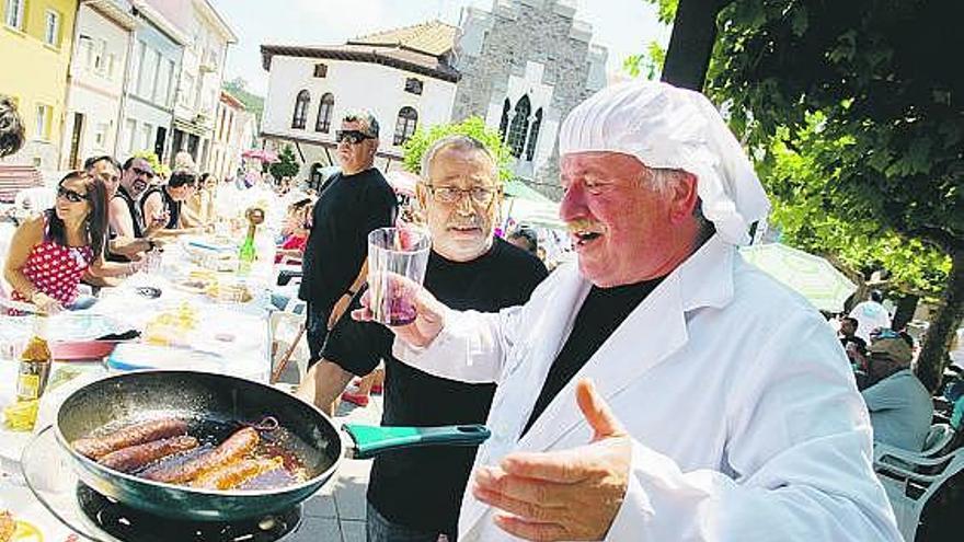 Armando Suárez García, ayer, elaborando el menú de calle en San Juan de la Arena a base de chorizo y panceta.