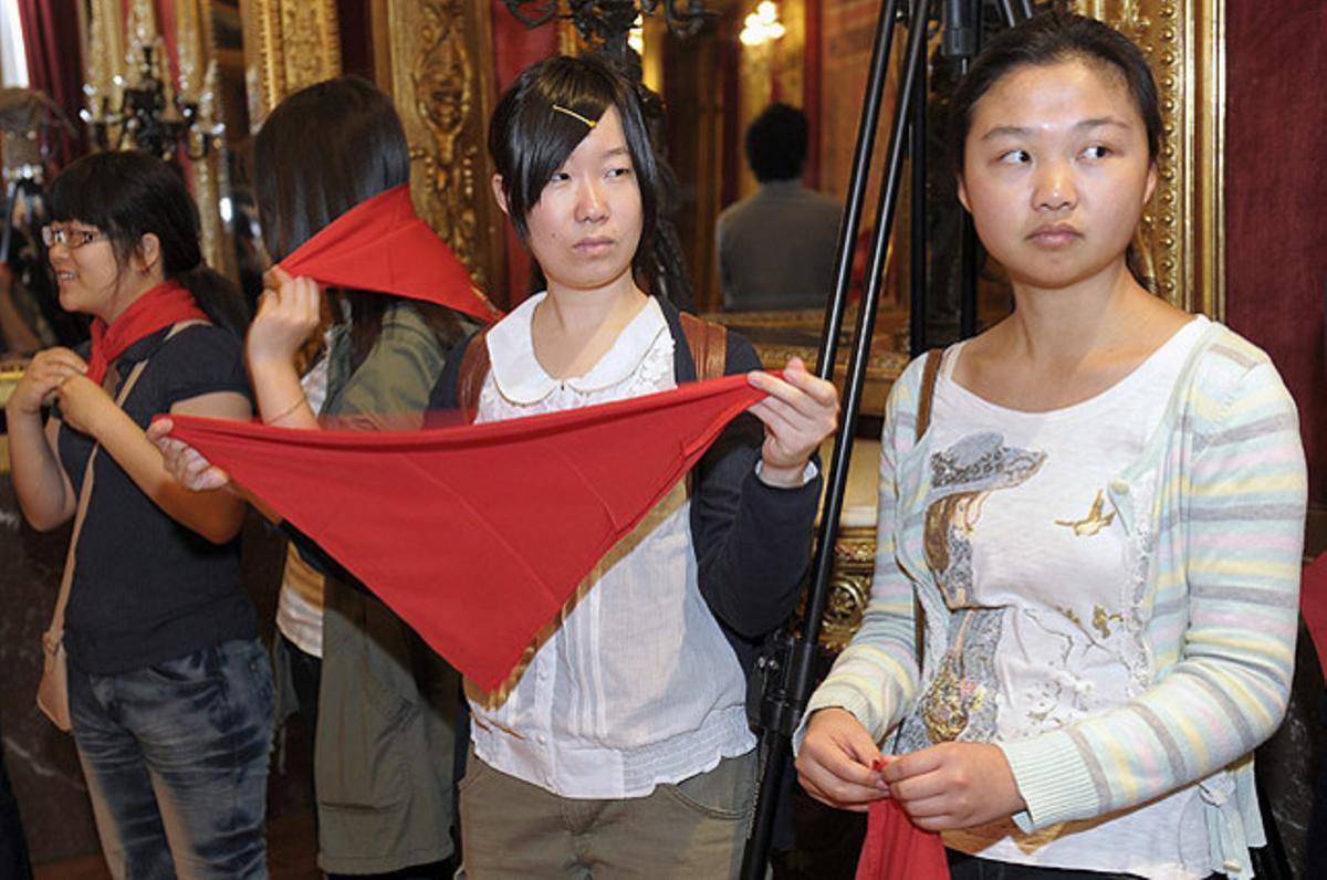 Dos estudiants es col·loquen el tradicional mocador de les festes Sant Fermí durant la recepció al palau de Navarra dels alumnes estrangers que estudien aquest curs a la Universitat Pública de Navarra (UPNA).