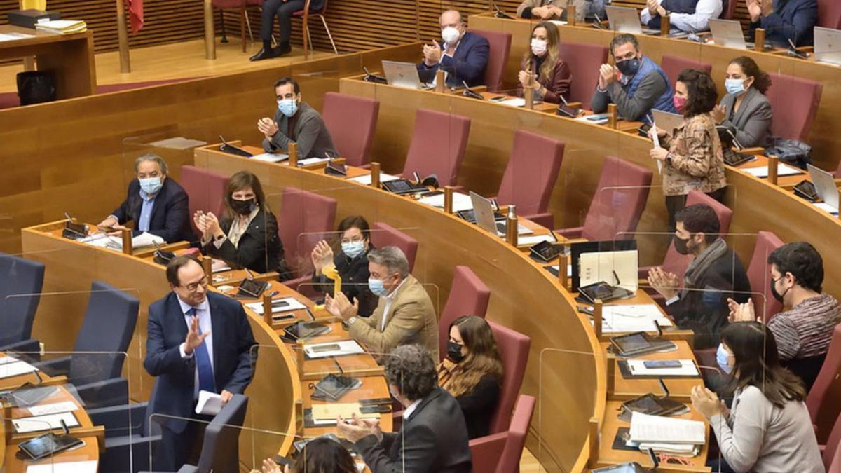 El conseller de Hacienda, Vicent Soler, saluda  diputados de PSPV y Compromís ayer en las Corts. | I.CABALLER