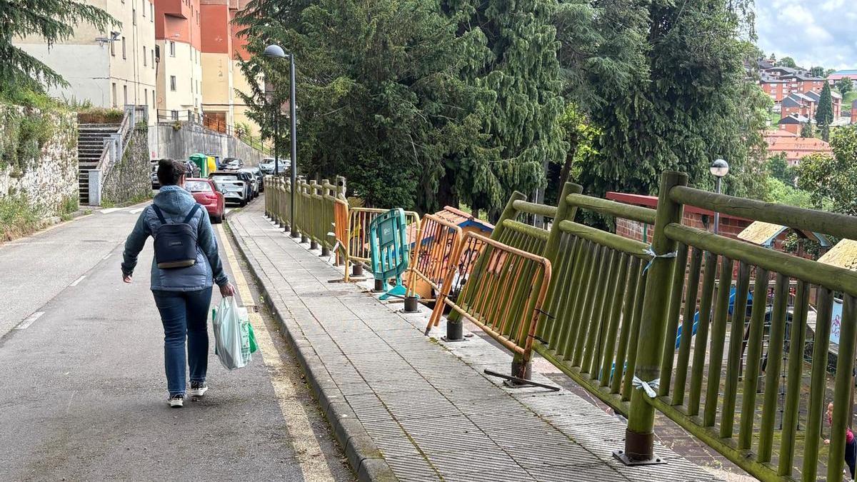 Vallas provisionales en una zona de la barandilla perimetral caída en el parque Verdeamor de Tineo.