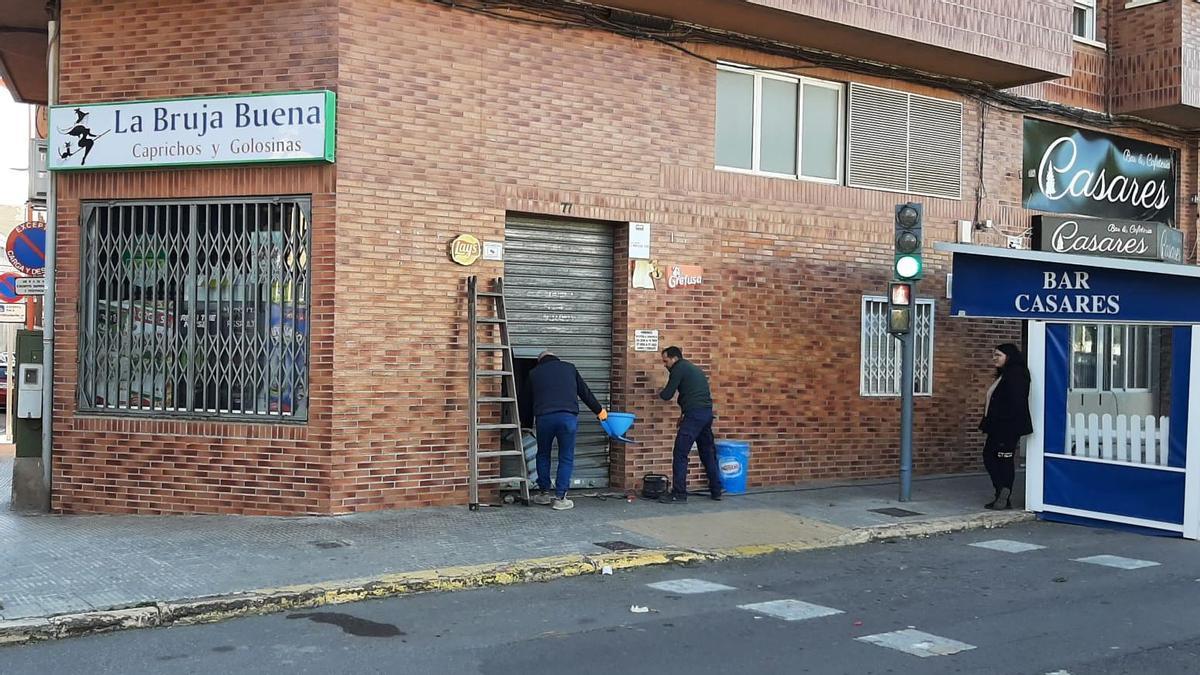 Dos operarios reparan la persiana tras el último robo en Vila-real.