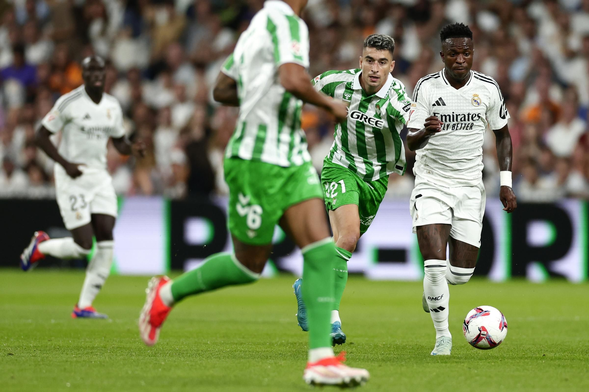 Real Madrid's Vinicius Junior, right, is challenged by Betis' Marc Roca during the Spanish La Liga soccer match between Real Madrid and Betis at the Santiago Bernabeu stadium in Madrid, Spain, Sunday, Sept. 1, 2024. (AP Photo/Pablo Garcia)