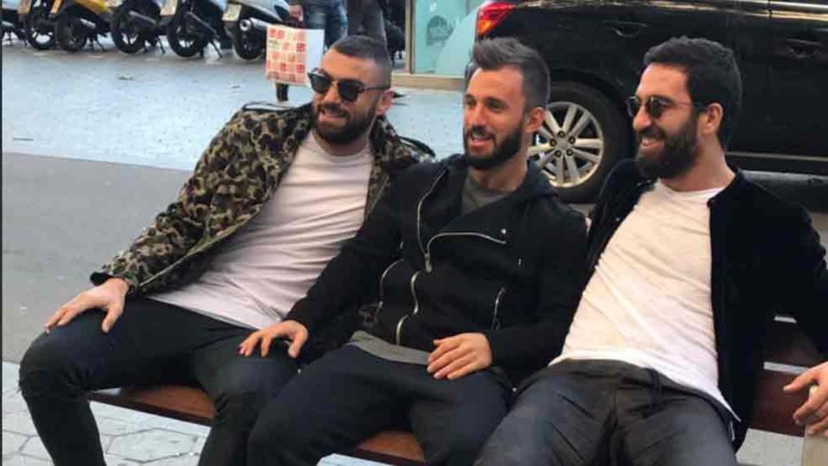 Arda Turan, con sus amigos, en un banco del Passeig de Gràcia de Barcelona