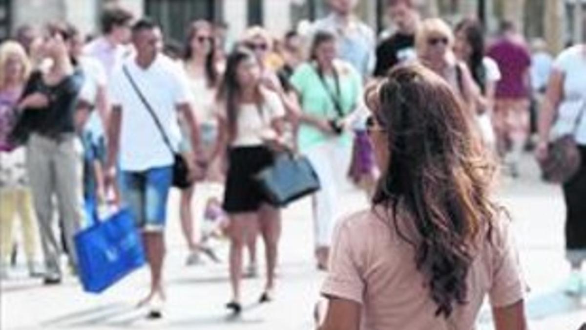 Una mujer pasea por una calle comercial de Barcelona en septiembre.