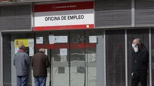 Dos personas leen los carteles de una oficina de empleo cerrada, el pasado lunes.