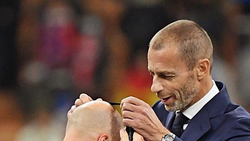 El árbitro de la final, Anthony Taylor, recibe una medalla conmemorativa del presidente de la UEFA, Aleksander Ceferin.