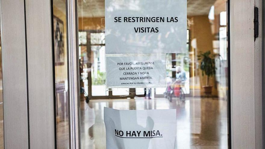 Entrada de una residencia de ancianos con un cartel preventivo.