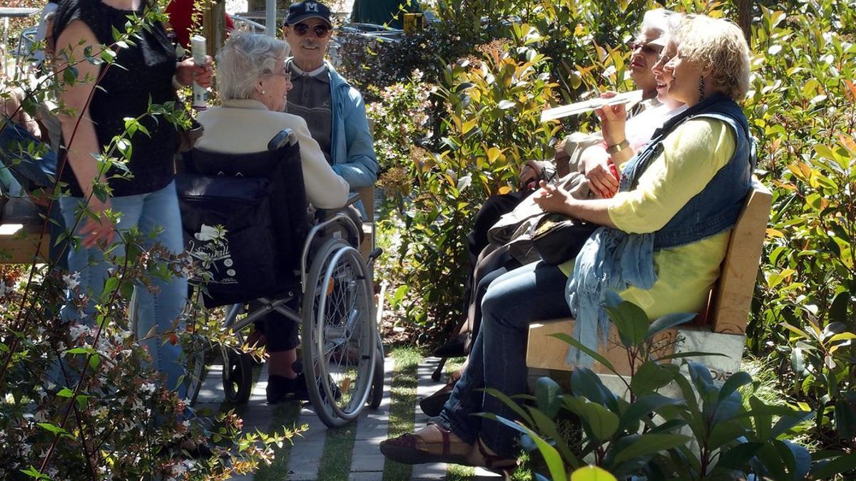 Un grupo de personas mayores conversando en el Passeig de Sant Joan de Barcelona.