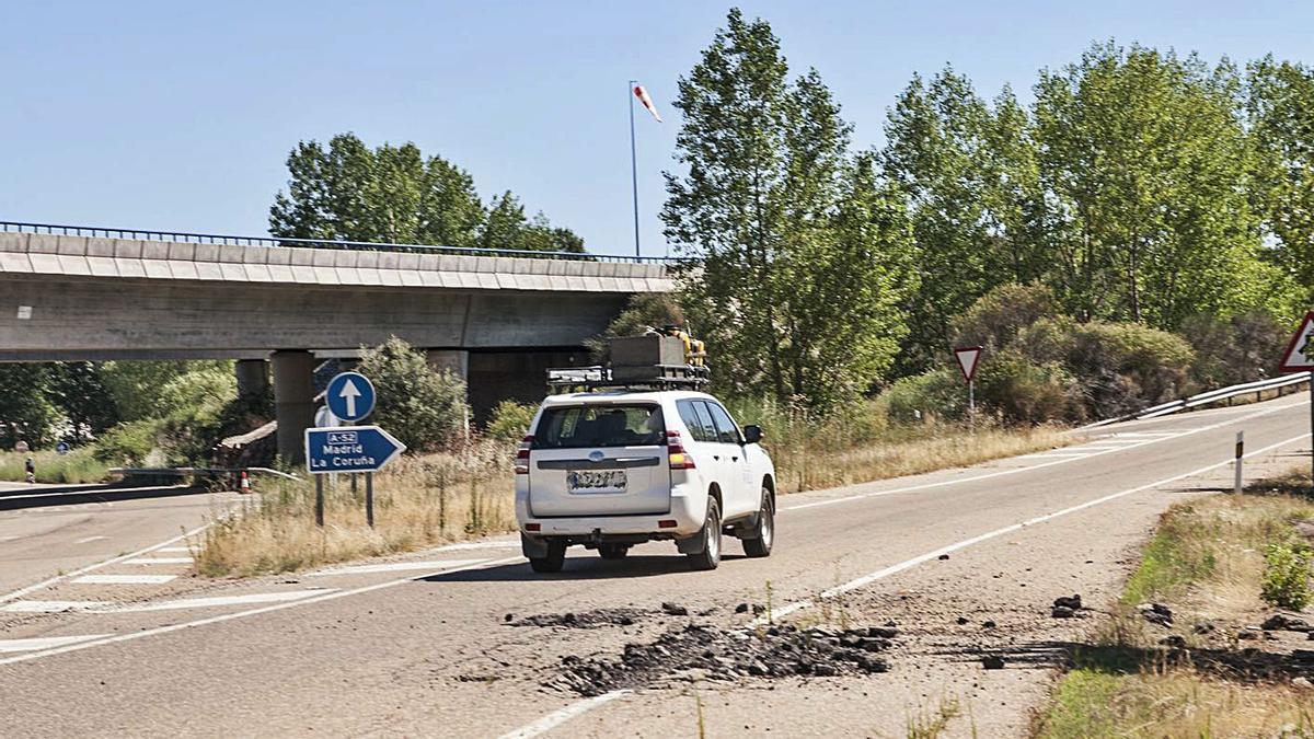 Un vehículo de la Junta se separa del enorme socavón del acceso a la A-6 en Villabrázaro.|J. A. G.