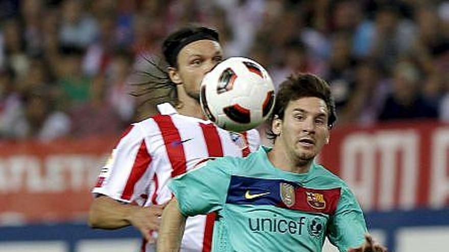 Messi intenta controlar el balón ante la mirada del defensa rojiblanco Ujfalusi.