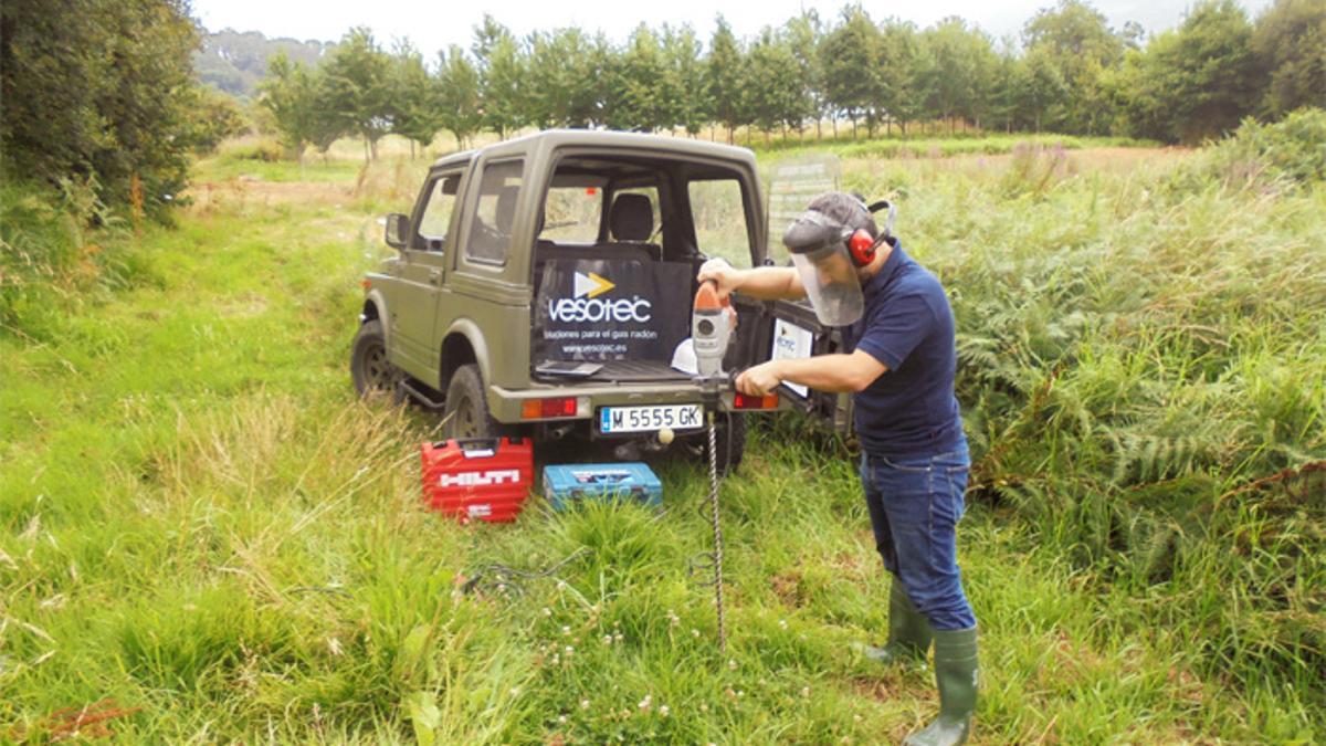 Un operario realizando unha medición de gas radon nun terreo