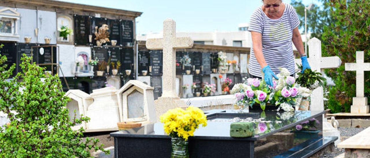 Alicia María Domínguez, ayer, en el camposanto del Puerto, mientras coloca un ramo de flores en la tumba de un familiar.