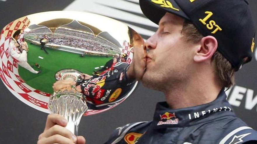 Vettel besa el trofeo que lo acredita como vencedor de la prueba india. / diego azubel