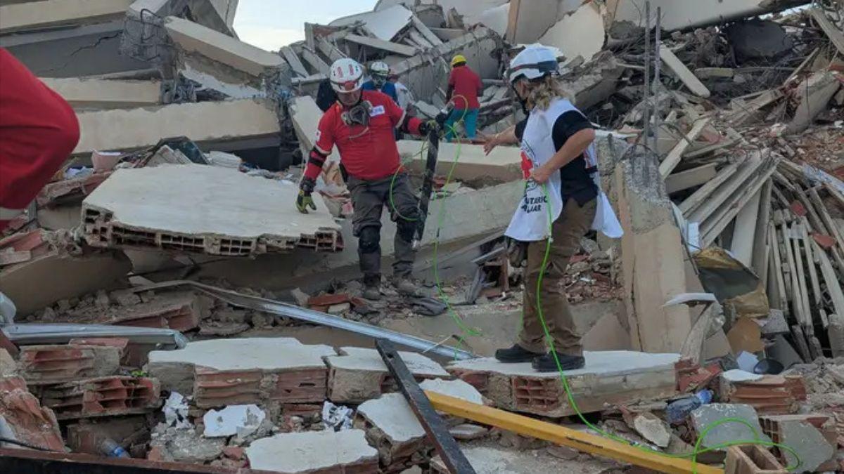 Los equipos de rescate y los técnicos se preparan para desplegar un robot serpiente en un edificio derrumbado para buscar sobrevivientes.