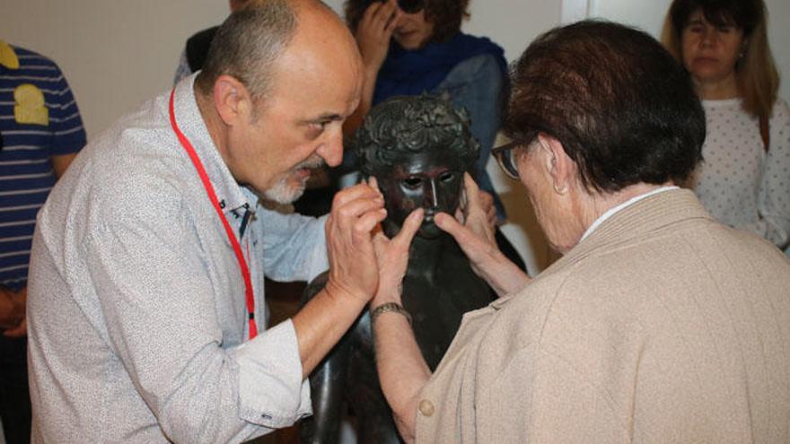 El director del museo, Manuel Romero, explica «El Efebo» a una persona discapacitada visual.